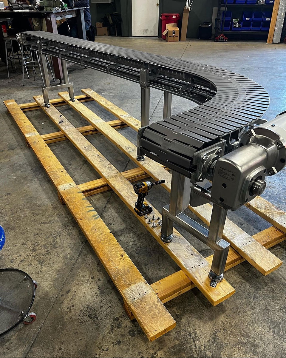 Curved conveyor on a stainless frame in the shop