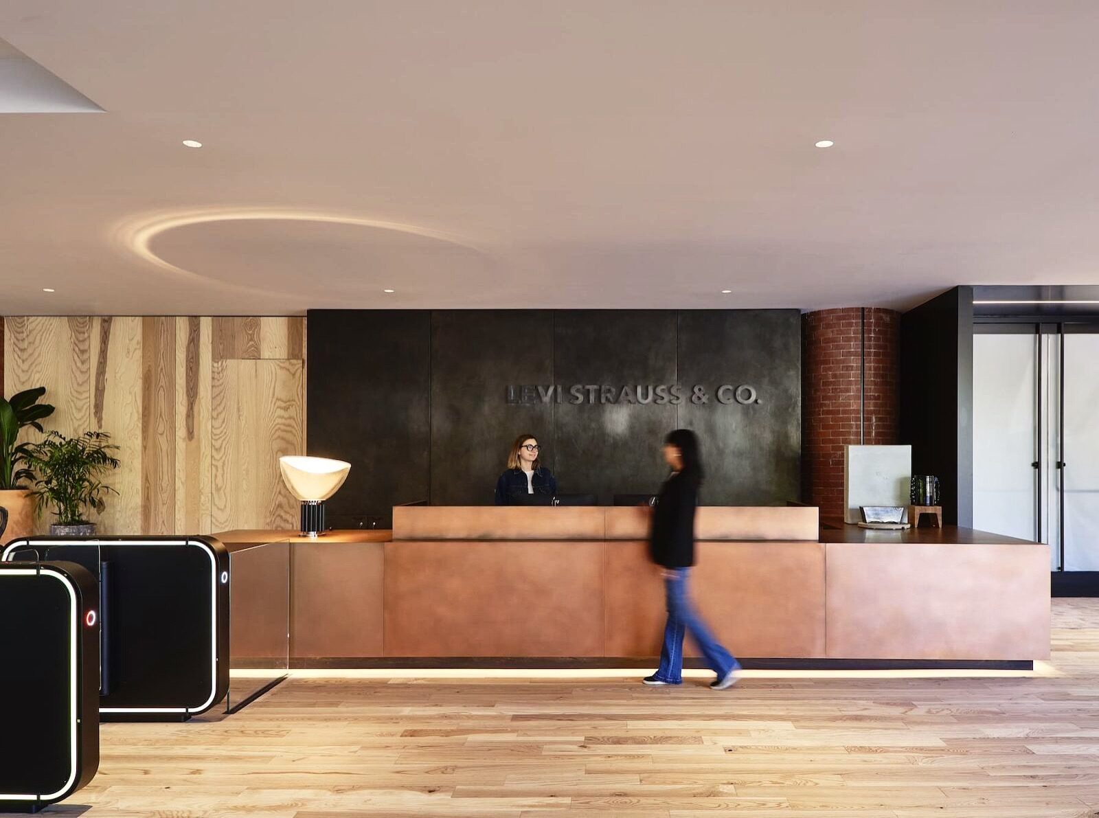 Copper reception desk in front of a blackened steel wall